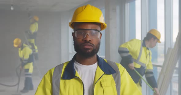 Portrait of Afroamerican Handyman Putting on Protective Glasses