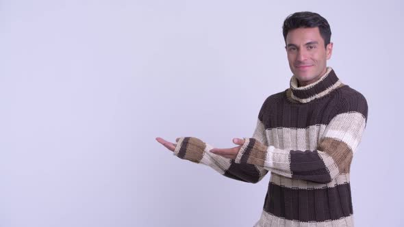 Young Happy Hispanic Man Showing Something Ready for Winter