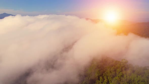 Aerial view from a drone over mountain fog during sunrise
