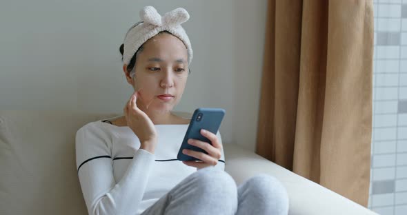 Woman Use of Mobile Phone with Paper Mask at Home