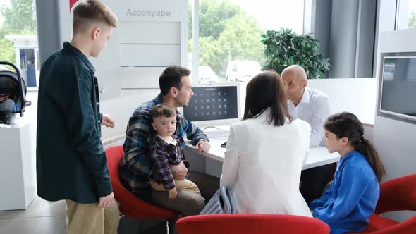 The Sales Manager Talks About the New Car Sitting in the Office the Family Buys a Car