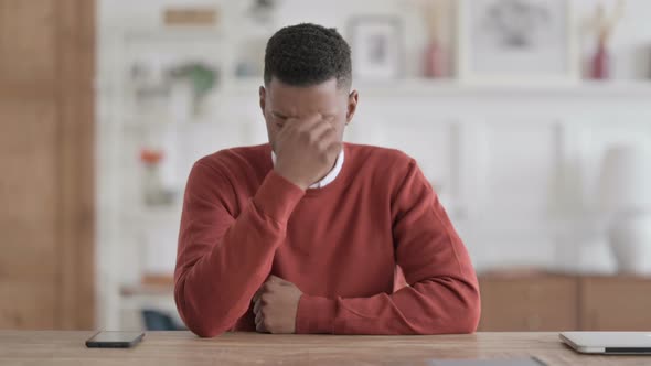 Upset African Man Feeling Worried While Sitting in Office