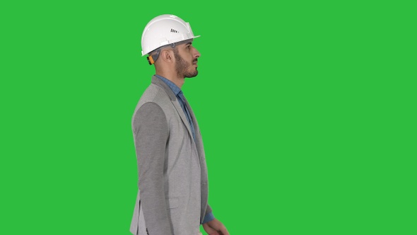Architect in white helmet walking on a Green Screen, Chroma Key