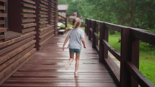 Little Girl in Shorts Runs Enjoying Freedom Along Terrace