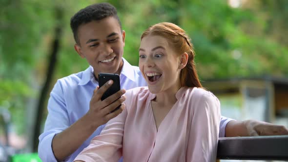 Teen Boy Showing Smartphone Screen Happy Girlfriend, Surprise for Anniversary