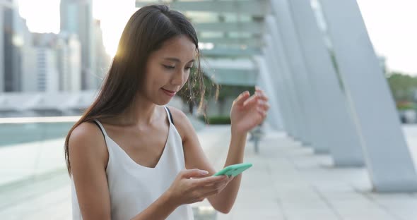 Woman typing on smart phone in city