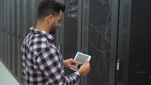 Male informatic engineer working inside server room database