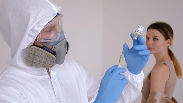 Closeup of a Doctor in a Medical Protective Suit Holding a Coronavirus Vaccine