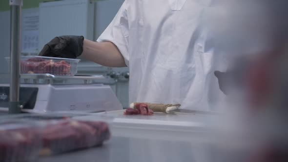 Worker in Black Proective Gloves Prepares Fresh Meat for Delivery to Stores