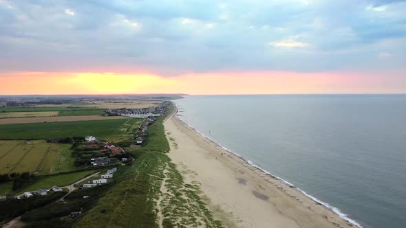 Static aerial shot of beach with fishing village on the coast of Norfolk, UK