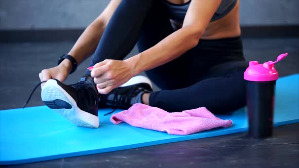 Close Up Shot of the Women's Feet, Who Ties Up the Shoelaces on the Sneakers