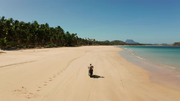 Man Driving a Motorcycle on Beach