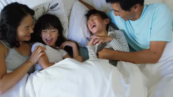 Happy family having fun on bed in the bed room 4k