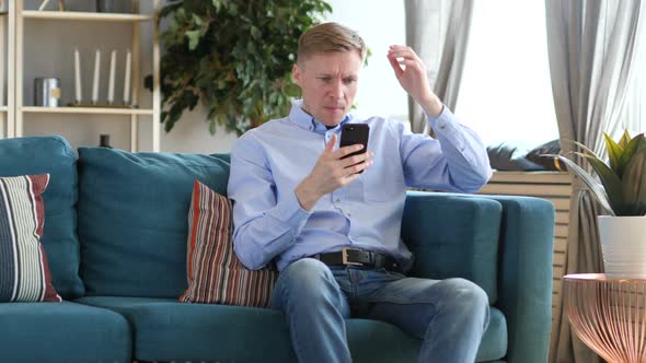 Middle Aged Man Upset for Loss While Using Smartphone