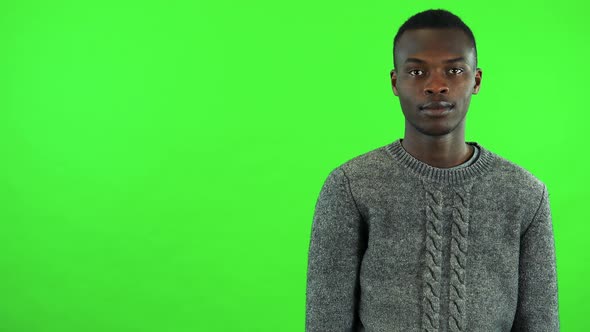 A Young Black Man Extends His Arm To the Camera for a Handshake - Green Screen Studio