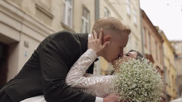 Newlyweds Caucasian Groom with Bride Walking Embracing Hugs in City Wedding Couple in Love