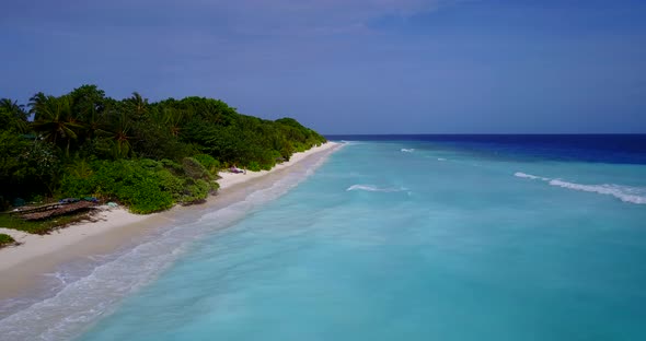 Tropical overhead tourism shot of a white sand paradise beach and aqua turquoise water background in