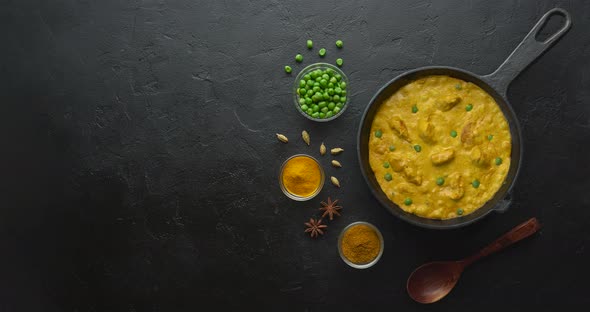 Cooking Tasty Chicken Curry Dish with Rice in A Cast Iron Pan