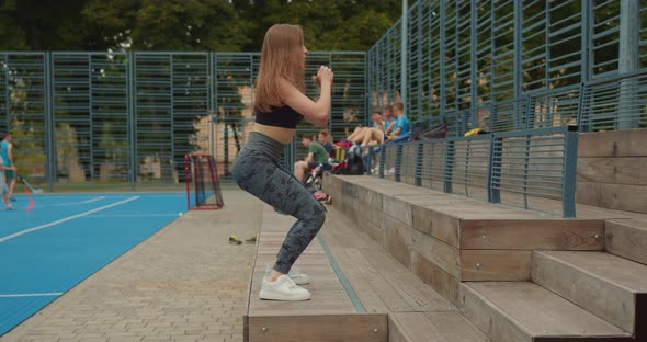 Sport Girl is Performing Squats with Jumping on the Step