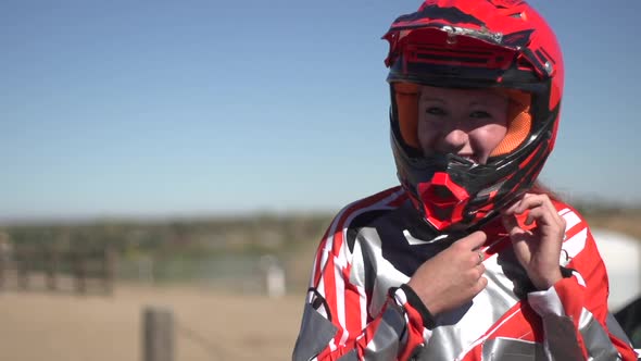 A young woman bmx rider putting on helmet.