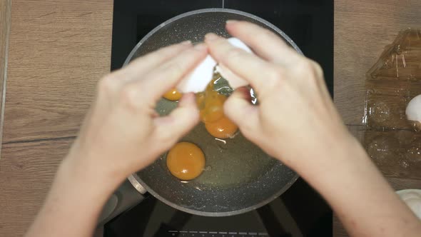 Fresh Eggs Break in Hot Frying Pan on Stove