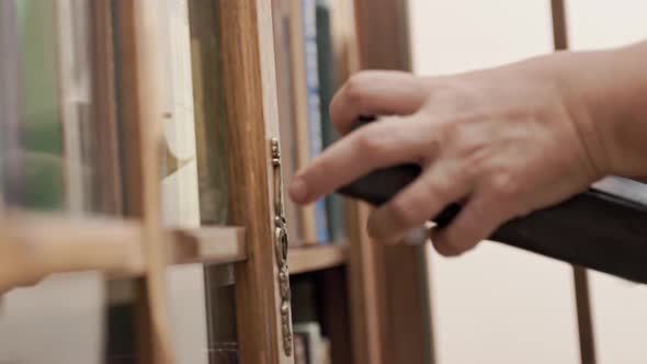 Caucasian woman handtake book on shelf.