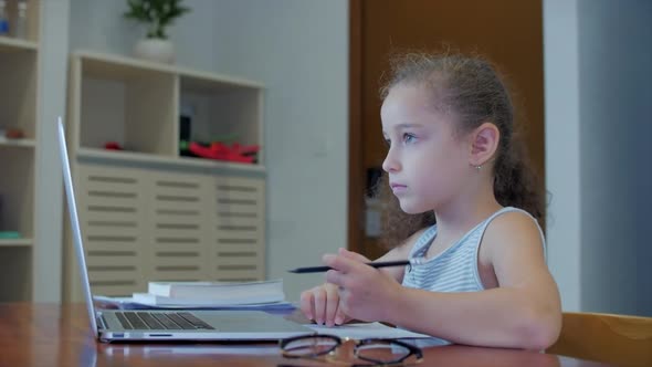 Little Girl a Cute Elementary School Child of 7-8 Years Old at Home Studying in Family Learning