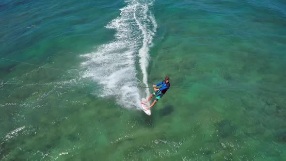 Aerial view of a man kitesurfing in Hawaii.