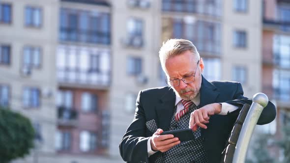 Man using phone on street. Confident businessman using cell phone on street
