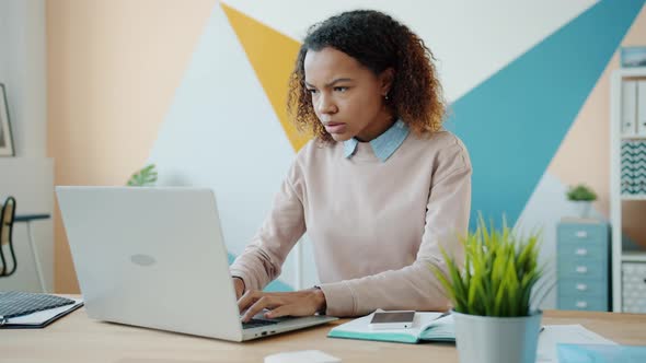 Young Afro-American Girl Using Laptop in Office Then Leaving Feeling Angry and Unhappy