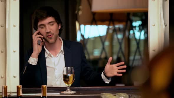 Young Successful Businessman Speaking on Phone in Cafe