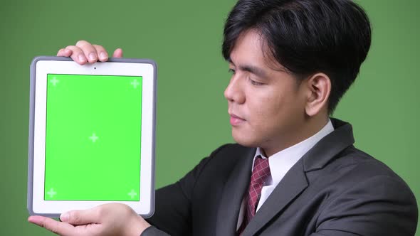 Young Handsome Asian Businessman Using Digital Tablet