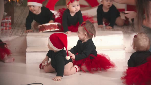 Christmas Concept - Little Babies Sitting on the Floor in Christmas Studio