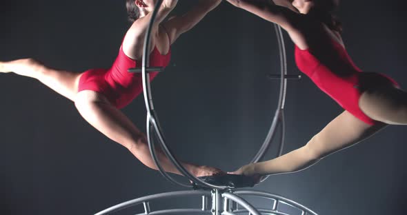 Women in Red Clothes are Doing Gymnastics Aerial Split with the Hoop