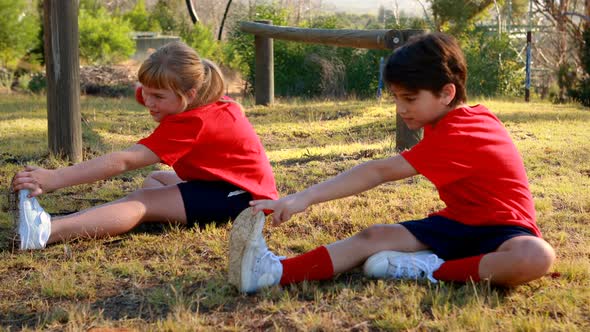 Kids performing stretching exercise in boot camp