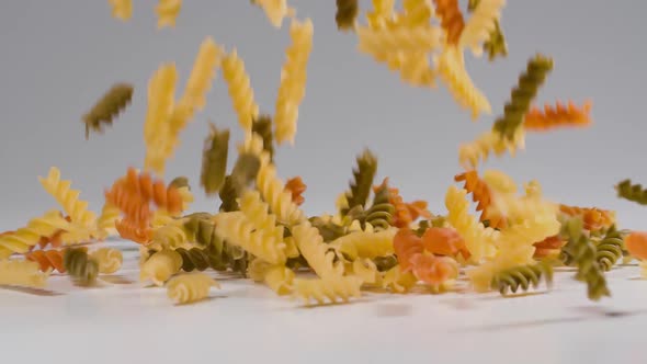 Pasta falling onto a white surface in slow motion