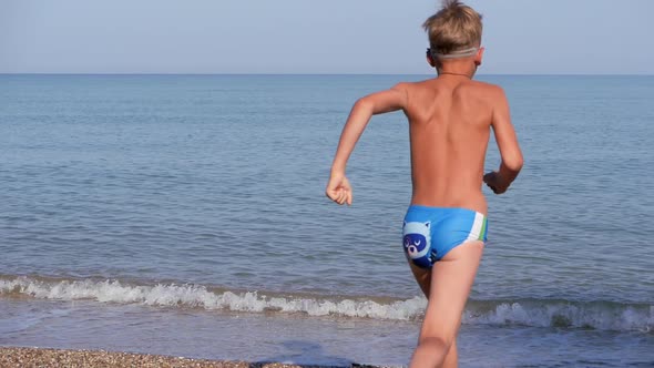 Boy Runs Into the Blue Water