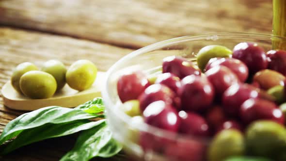 Herbs and fresh red and green olives in bowl