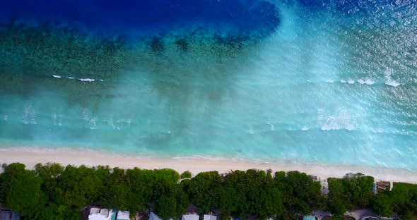 Natural overhead abstract shot of a white paradise beach and blue water background in 4K