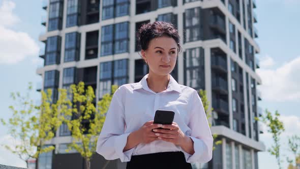 Adult Pretty Businesswoman Using Mobile Phone Texting Message Outside