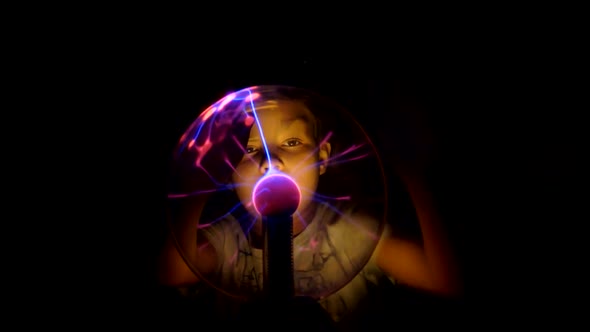 Boy Moves in the Tesla Lamp with His Hands