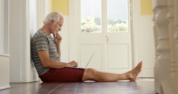 Senior man using laptop at home 4k
