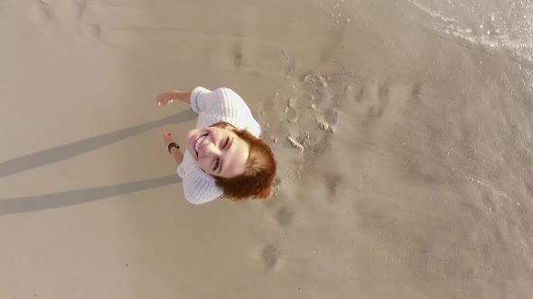 Drone Footage Closeup Young Smiling Girl Spinning with Stretched Out Arms Looking Up Touching Her