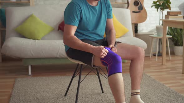 Man Athlete Preparing for Training with a Bandage on His Knee