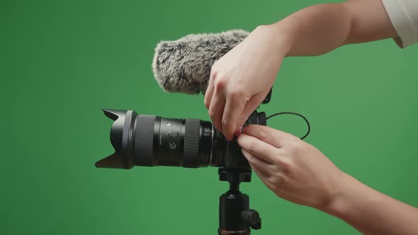Close Up Hands Male Put Microphone On Digital Camera In Green Screen Studio