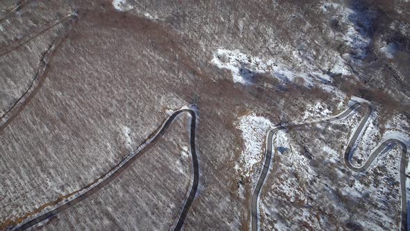 Aerial view of a winding road in the snowy hills of Greece.