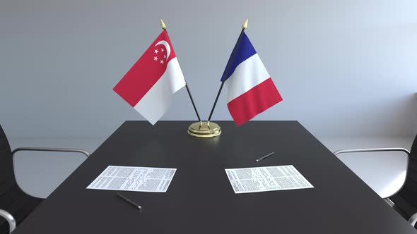 Flags of Singapore and France and Papers on the Table