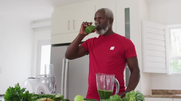 Senior african american man drinking fruit and vegetable health drink at home