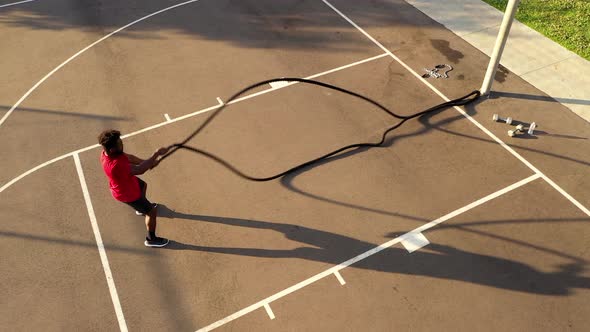 Aerial shot of a man working out with battle ropes