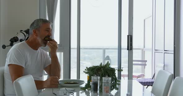 Man eating breakfast on table at home 4k